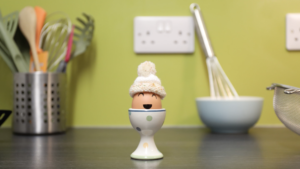 still from egg animation: Egg in eggcup with hat on