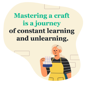 Background light yellow and designed to look like a brick wall and an illustration of a potter holding a jug in black and white stripey top and pottery apron, with the wording 'Mastering a craft is a journey of constant learning and unlearning.'